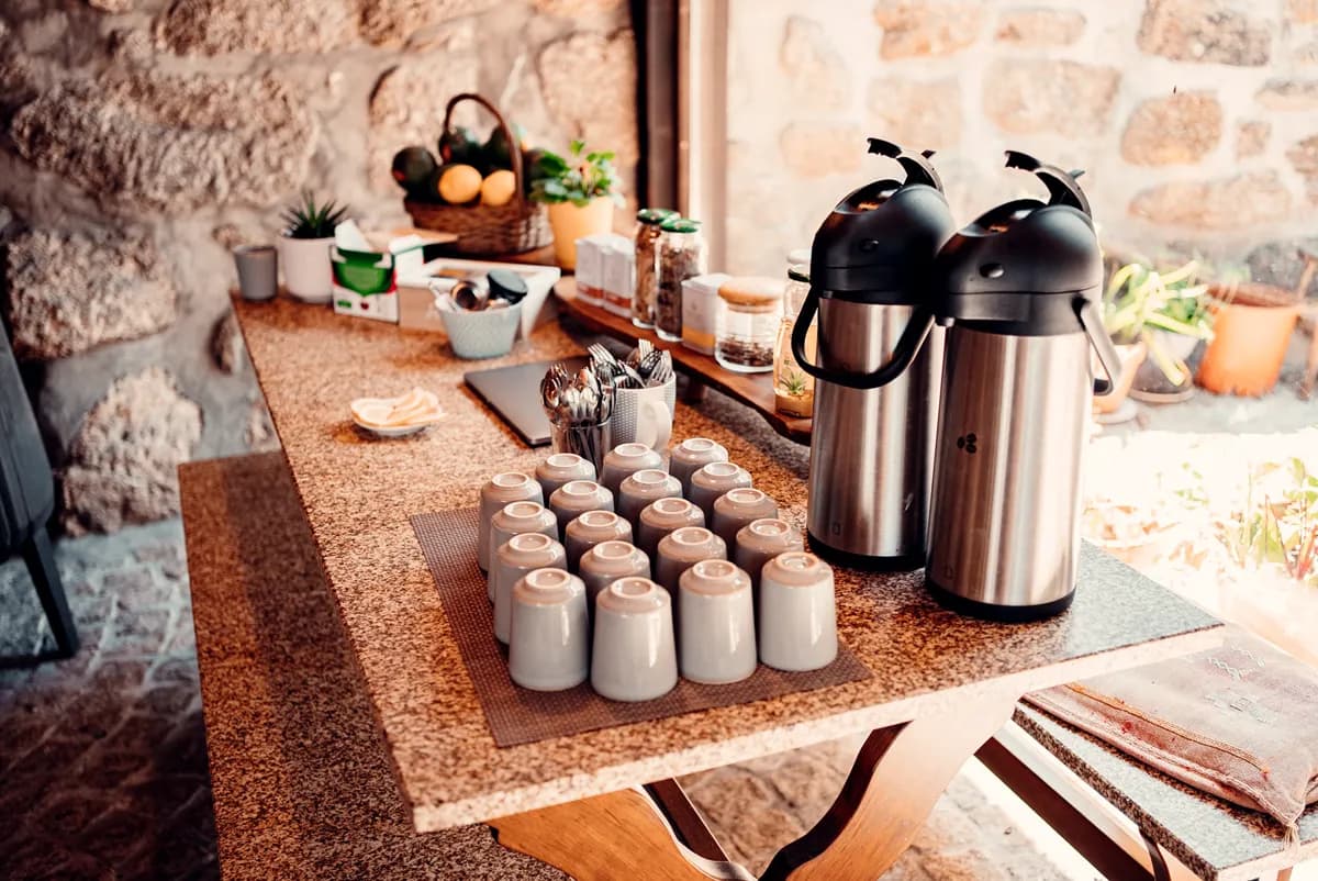 Coffee and tea station with ceramic cups on a stone counter at Quinta do Rabaçal