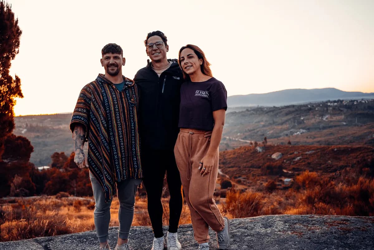Tommy, Claire and Al standing together on a hilltop at sunset overlooking the Portuguese valley