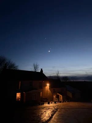 The farmhouse at dusk under a starlit sky