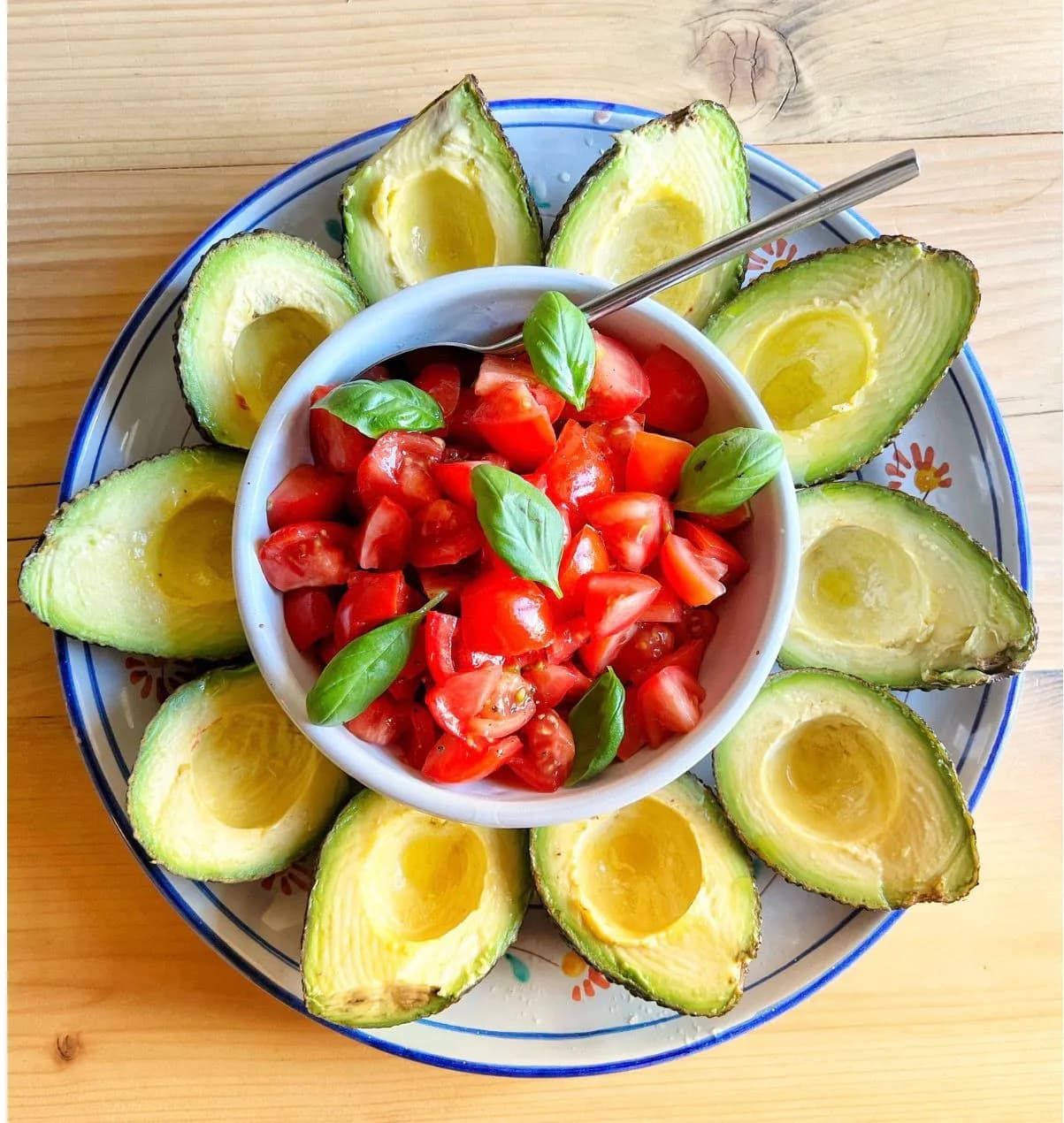 Fresh avocado halves with tomato and basil salad